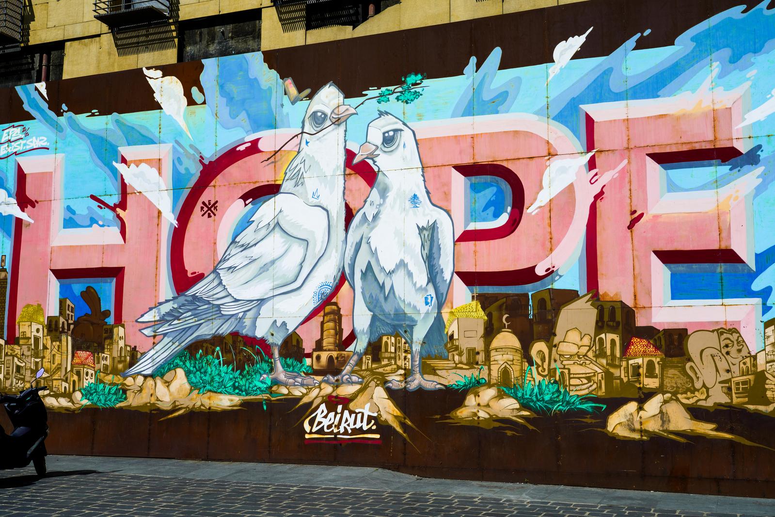 Hoffnung – englisch Hope – steht in Großbuchstaben auf einem Graffito in Beirut mit zwei Friedenstauben im Vordergrund.