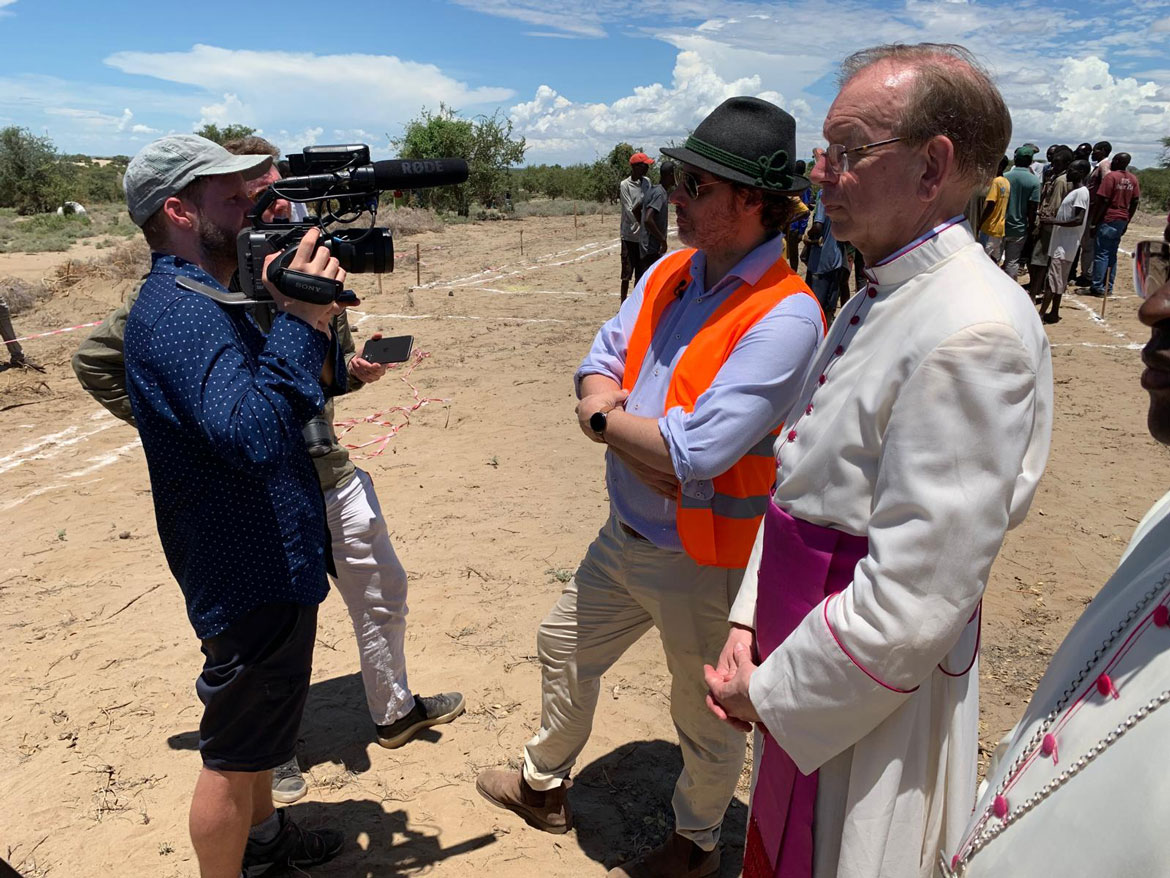 Prinz Ludwig im Gespräch mit einem Kamerateam. Neben ihm stehen Monsignore Wolfgang Huber und der örtliche Bischof.