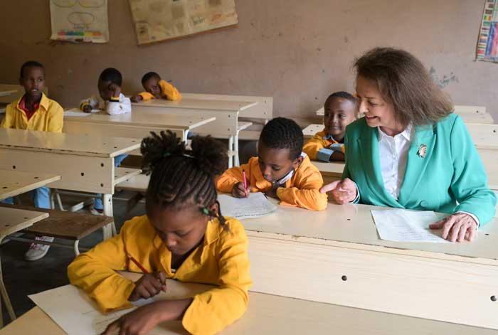 Uschi von Luttitz sitzt in einem Klassenzimmer im Waisenhaus in Aethiopien und schaut zu, was das neben ihr sitzende Kind schreibt.