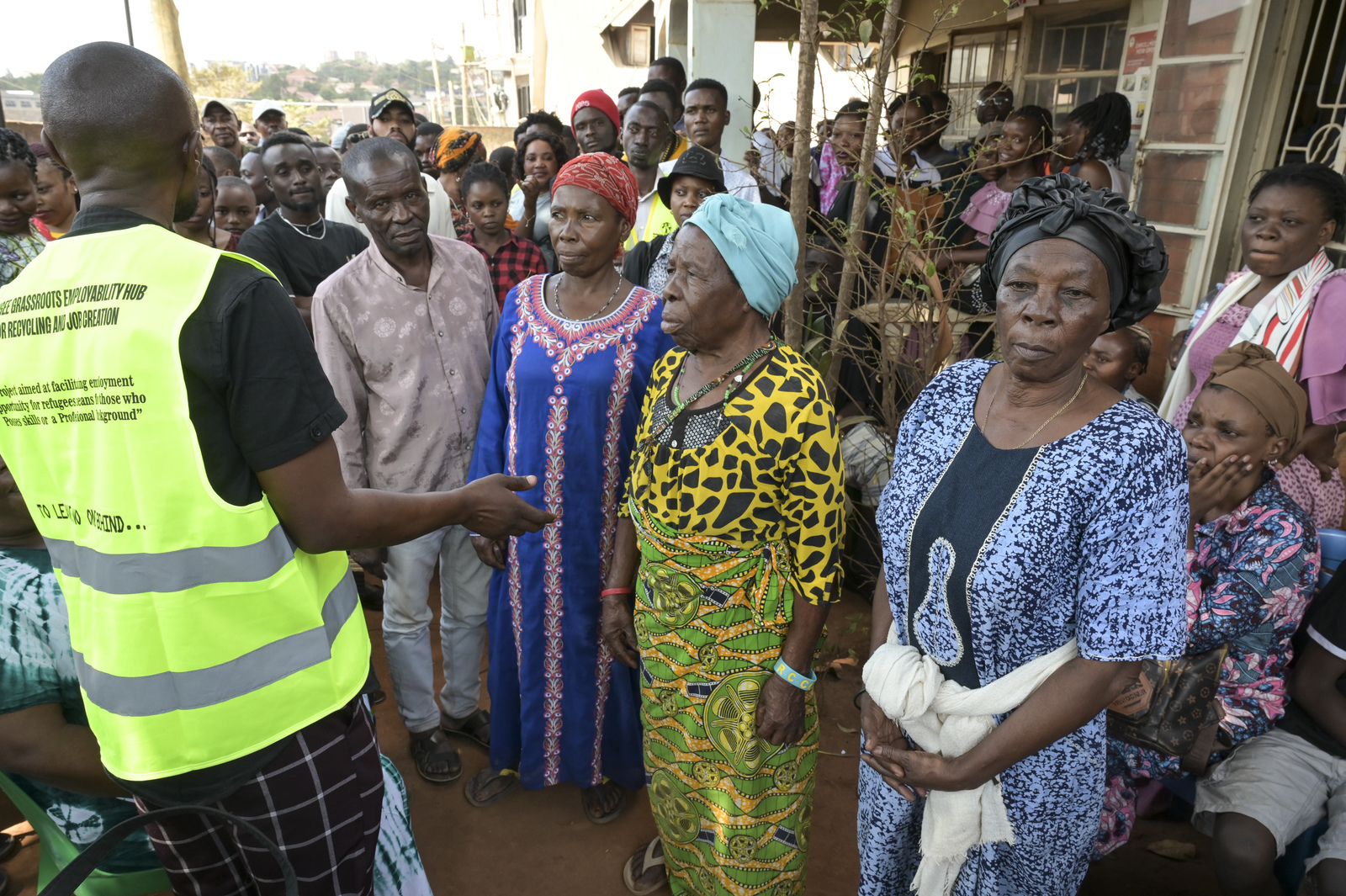 Ein Mann vom Jesuit Refugee Service in Kampala erklärt neu angekommenen Flüchtlingen, wie sie Hilfe erhalten. Jörg Böthling/missio München