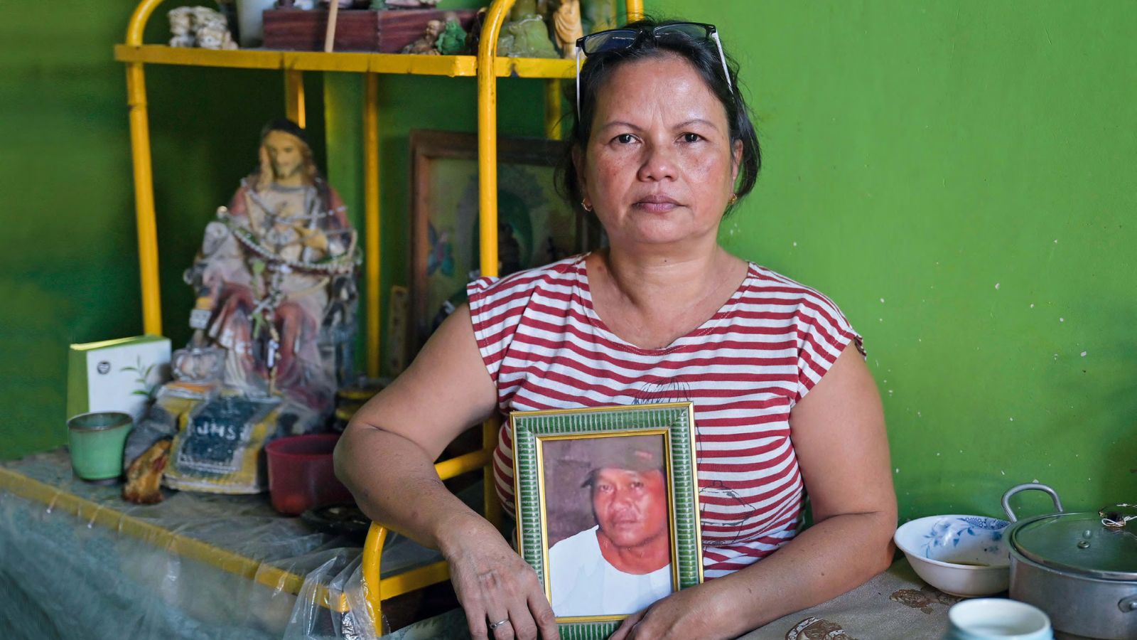 Eine Frau, deren Mann Opfer der außergerichtlichen Tötungen im Krieg gegen die Drogen wurde, hält ein Bild des Verstorbenen in den Händen.