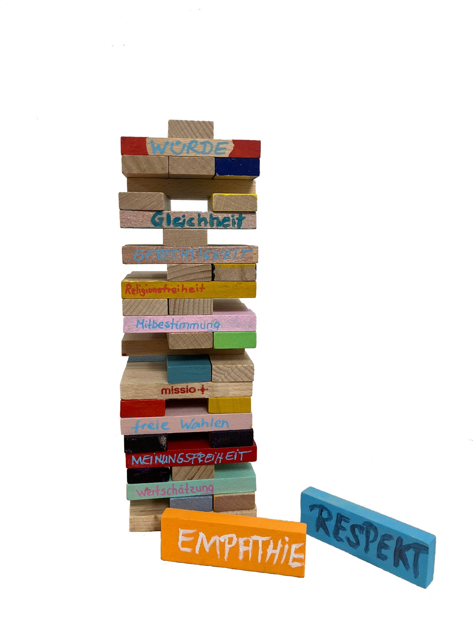 Ein bunt bemalter Holzstapelturm aus Jengasteinen ist beschriftet mit demokratischen Werten wie Respekt, Empathie, Meinungsfreiheit etc.