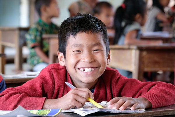 Ein Junge lacht in einer Schule in Indien