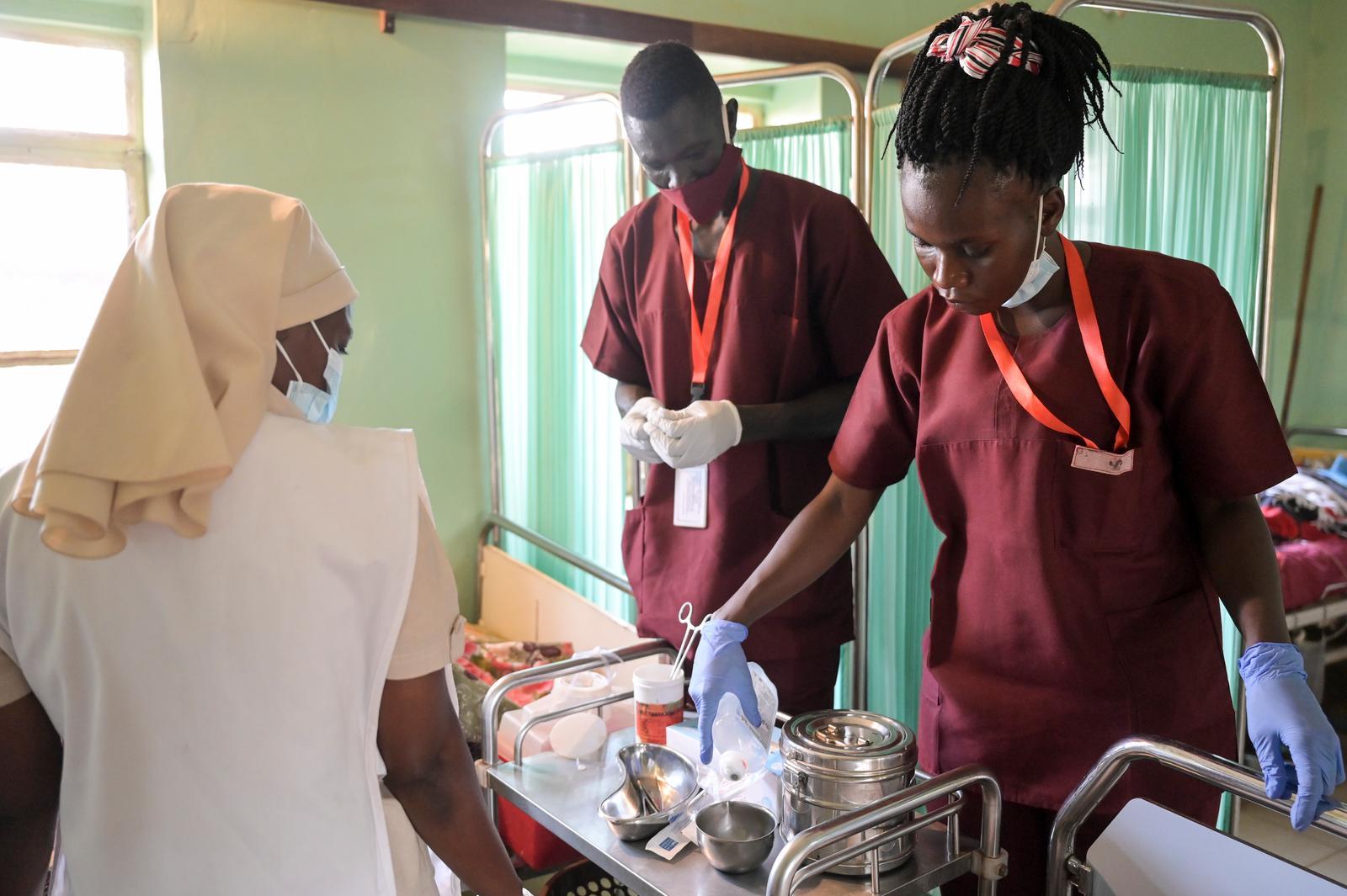 Auszubildende eines Krankenhauses in Wau im Südsudan ordnen auf einem Wagen Medikamente und Zubehör.