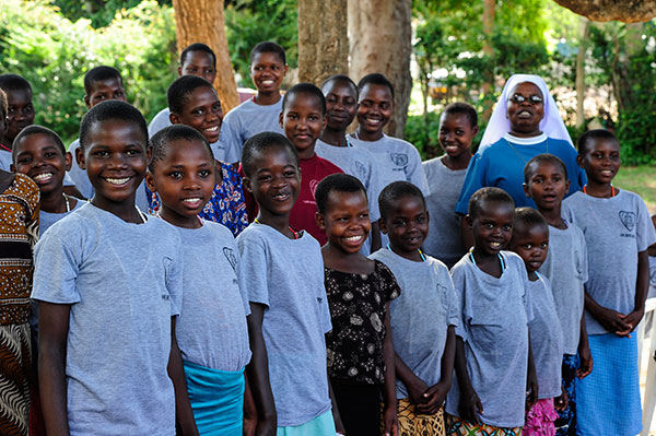 Gruppenbild mit Kindern in Jipe Moyo und einer Schwester. Alle lachen.