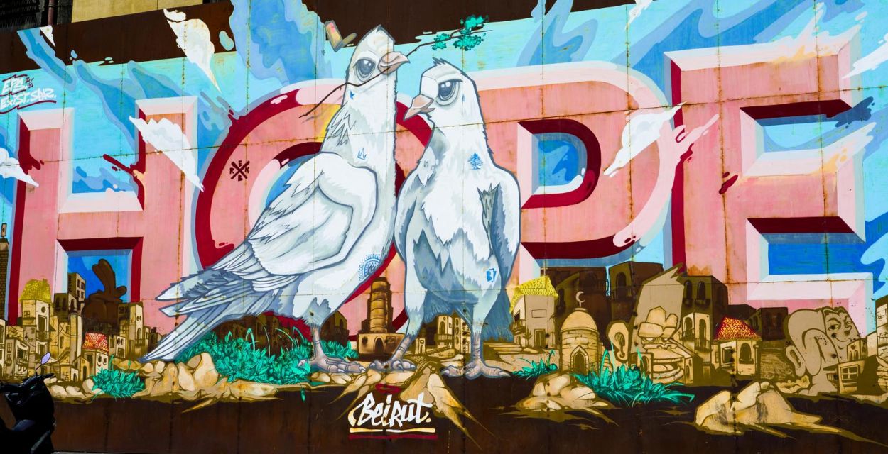 Hoffnung – englisch Hope – steht in Großbuchstaben auf einem Graffito in Beirut mit zwei Friedenstauben im Vordergrund.