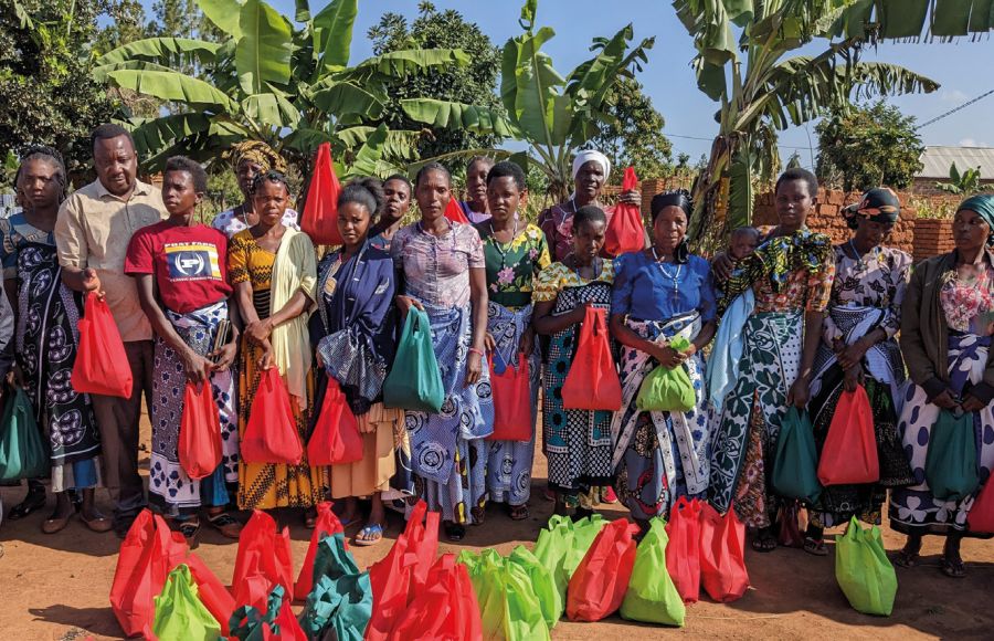Father Gratian gemeinsam mit einer großen Gruppe von Frauen aus Gemeinden der Diözese Ngara. Er hat zuvor Saatgut an sie ausgegeben, das sie dann zuhause auf ihren Feldern aussäen können.