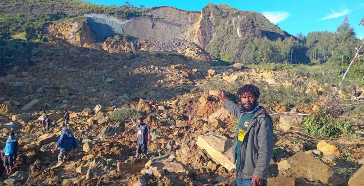 Ein Mann zeigt auf einen Hang, aus dem ein großer Abschnitt herausgespült wurde. Nach dem verheerenden Erdrutsch in Papua-Neuguinea werden hunderte Tote befürchtet.
