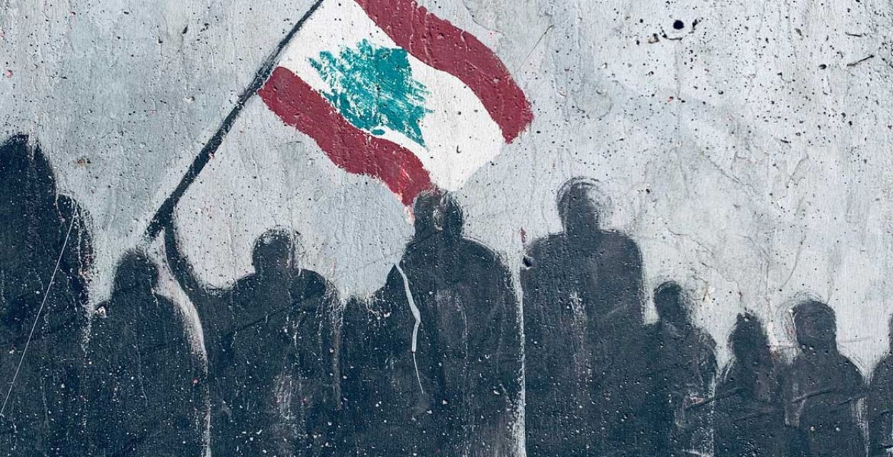 Ein Wandgraffiti zeigt Umrisse von Menschen, die eine Libanon-Flagge mit dem Zedernbaum schwingen.