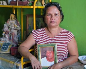 Eine Frau, deren Mann Opfer der außergerichtlichen Tötungen im Krieg gegen die Drogen wurde, hält ein Bild des Verstorbenen in den Händen.