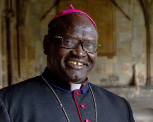 Der Bischof von Darfur steht im gotischen Kreuzgang einer Kirche.