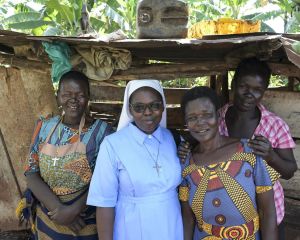 Gruppenfoto von vier Frauen: Die zweite von links ist Schwester Veronica, die anderen sind Bewohnerinnen des eines Slums in Uganda.