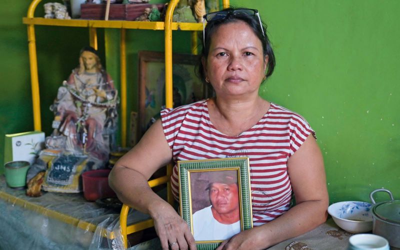 Eine Frau, deren Mann Opfer der außergerichtlichen Tötungen im Krieg gegen die Drogen wurde, hält ein Bild des Verstorbenen in den Händen.